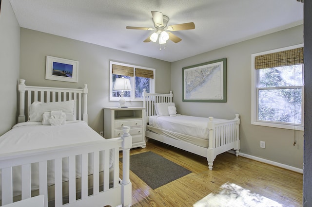 bedroom featuring a textured ceiling, light hardwood / wood-style floors, and ceiling fan