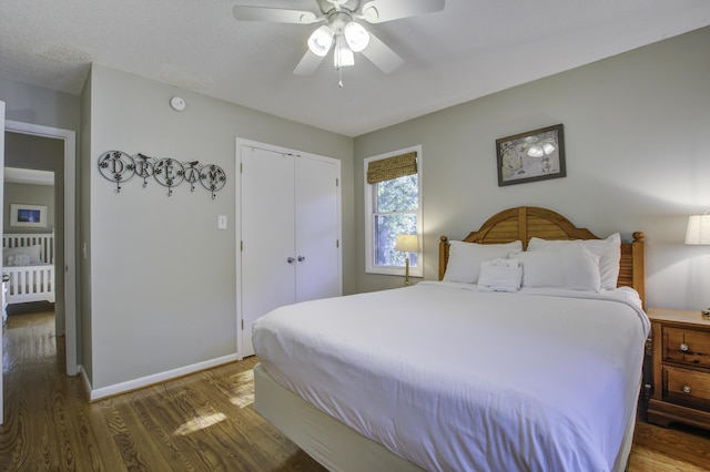 bedroom featuring a textured ceiling, a closet, ceiling fan, and dark wood-type flooring