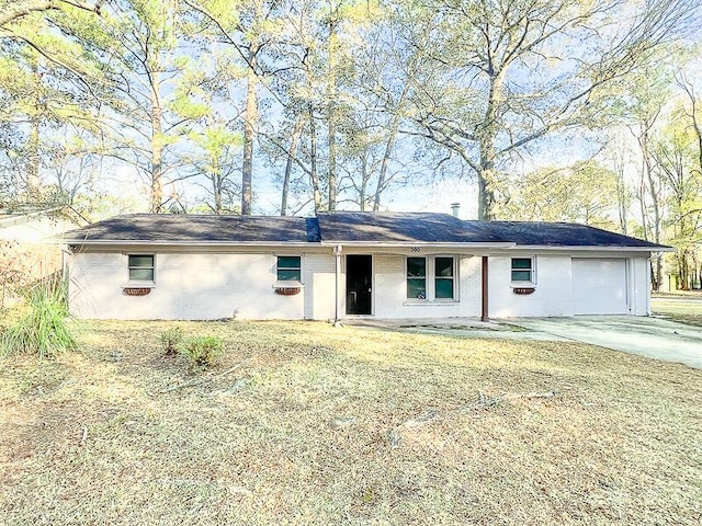 ranch-style home featuring a garage and a front lawn