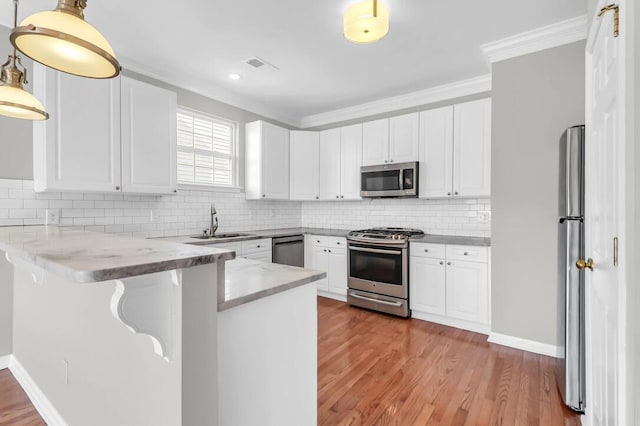 kitchen with white cabinetry, stainless steel appliances, and kitchen peninsula