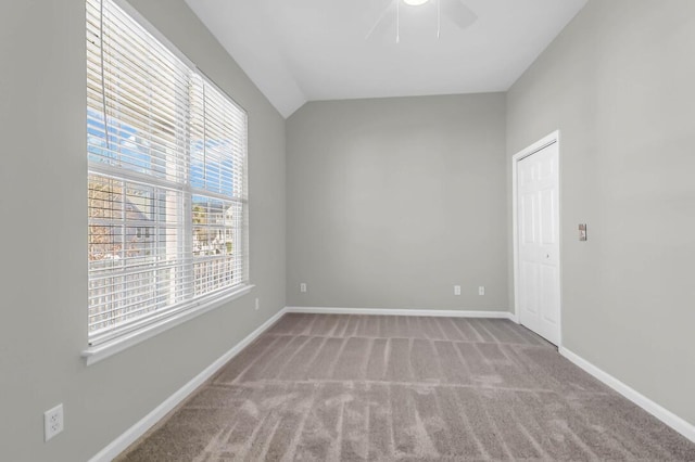 carpeted empty room featuring ceiling fan and lofted ceiling