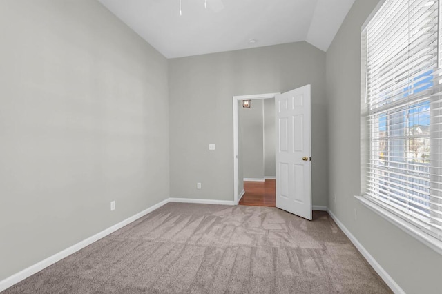 unfurnished bedroom with vaulted ceiling and light carpet