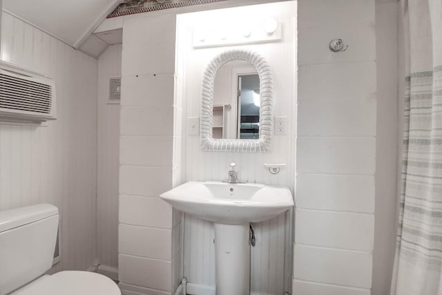 bathroom featuring sink, a shower with curtain, vaulted ceiling, and toilet