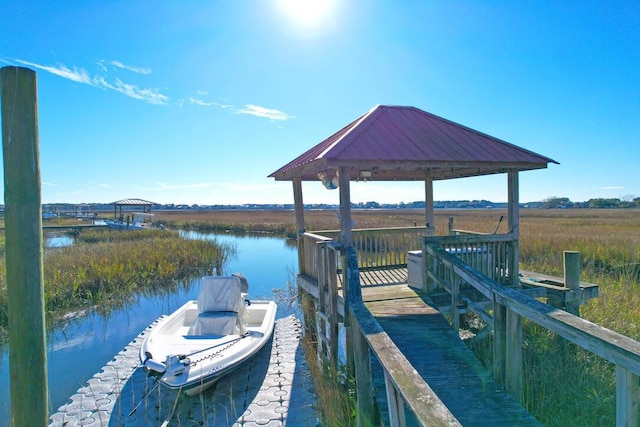 view of dock with a gazebo and a water view