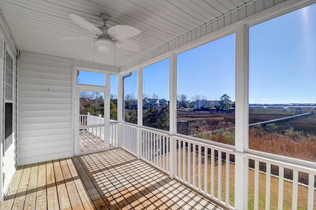 unfurnished sunroom featuring ceiling fan