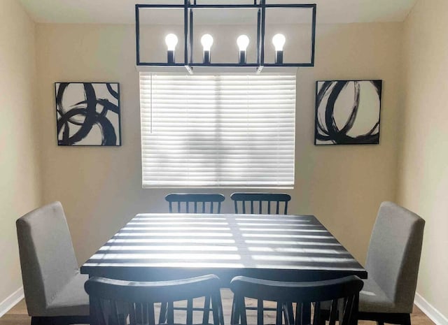 dining area with dark hardwood / wood-style floors and a chandelier