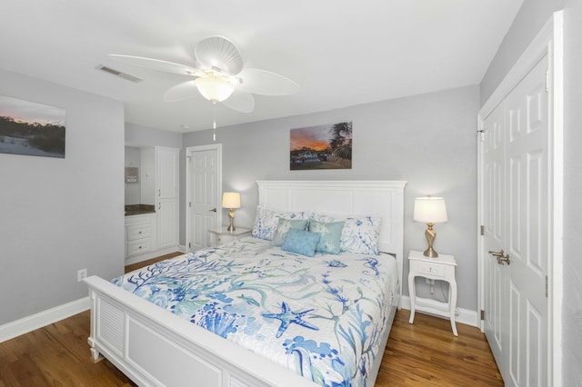 bedroom with a ceiling fan, wood finished floors, visible vents, and baseboards