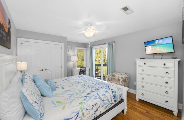 bedroom with visible vents, wood finished floors, a closet, baseboards, and ceiling fan