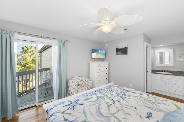 bedroom featuring ceiling fan, access to outside, wood finished floors, and a sink