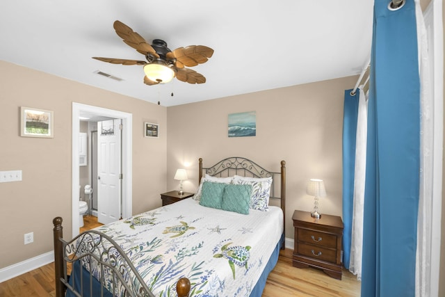 bedroom featuring a ceiling fan, visible vents, baseboards, light wood-style floors, and ensuite bathroom