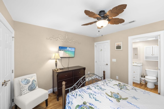 bedroom with visible vents, a ceiling fan, wood finished floors, connected bathroom, and baseboards