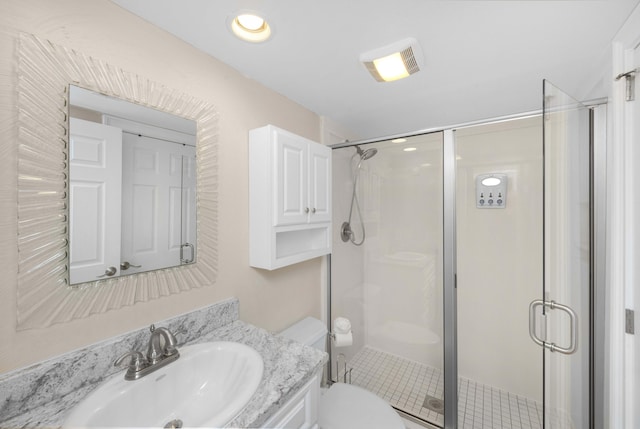 bathroom featuring vanity, a shower stall, toilet, and visible vents