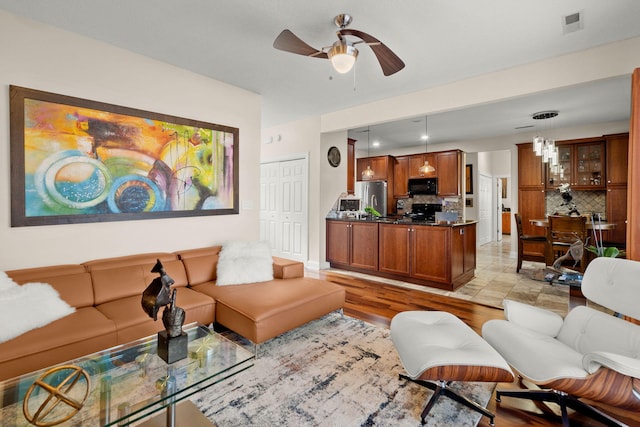 living room with ceiling fan and light hardwood / wood-style flooring