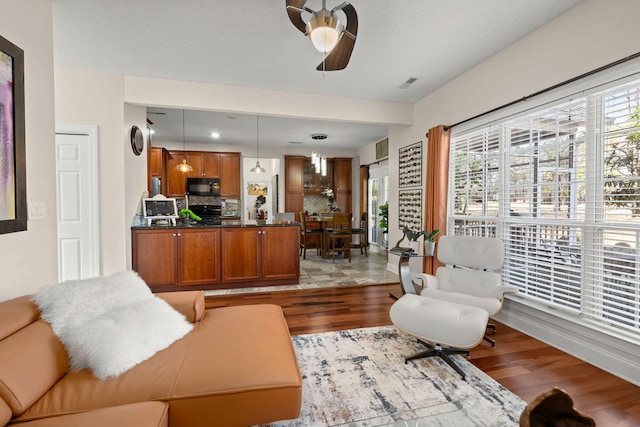 living room featuring ceiling fan and light hardwood / wood-style flooring