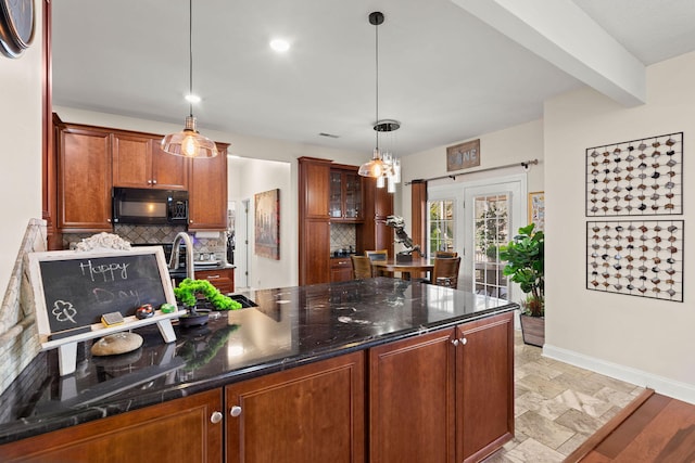 kitchen featuring dark stone countertops, hanging light fixtures, beam ceiling, backsplash, and sink