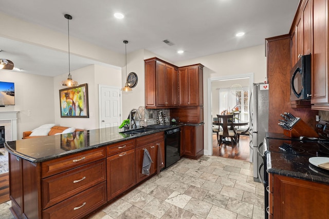 kitchen with decorative light fixtures, dark stone countertops, black appliances, and kitchen peninsula