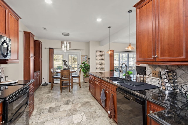 kitchen with black appliances, dark stone counters, sink, decorative light fixtures, and backsplash