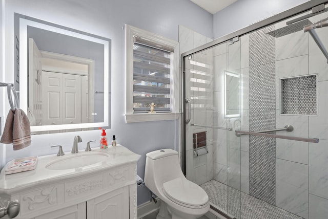 bathroom with toilet, an enclosed shower, and vanity