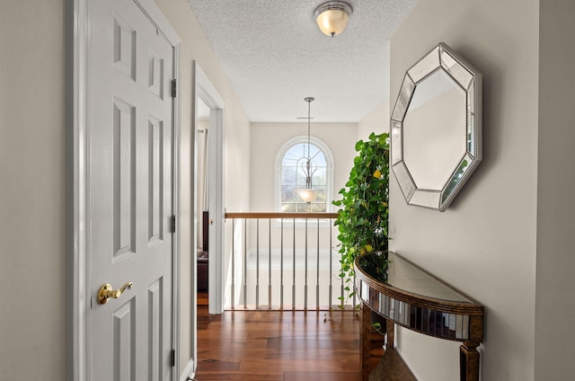 hallway with dark wood-type flooring and a textured ceiling