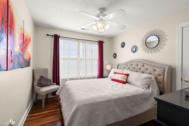 bedroom featuring a textured ceiling, ceiling fan, and dark hardwood / wood-style floors