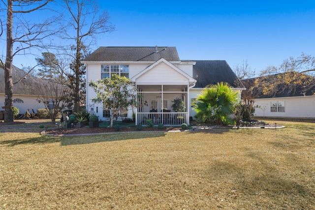 rear view of property featuring a lawn and covered porch