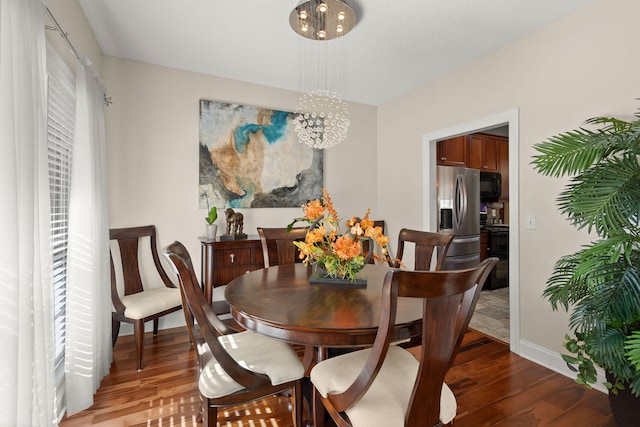 dining area with a chandelier and wood-type flooring