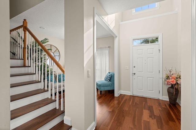 entrance foyer featuring a textured ceiling and dark hardwood / wood-style floors