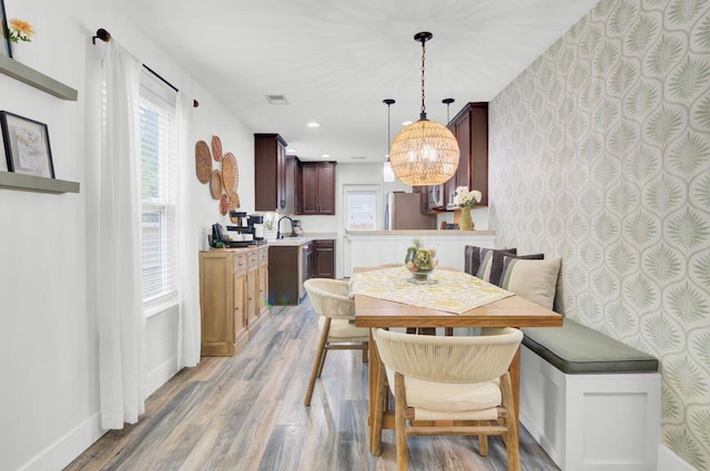 100 Runnels Cv, Summerville, SC 29485 - dining space featuring light wood-style flooring, a chandelier, healthy amount of natural light, wallpapered walls, and baseboards