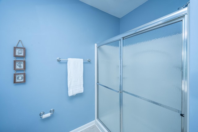 bathroom featuring an enclosed shower and baseboards