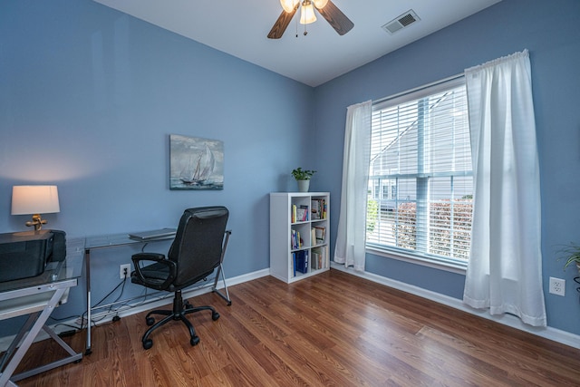 office with ceiling fan, visible vents, baseboards, and wood finished floors