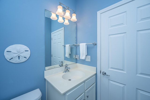 half bath featuring toilet, a chandelier, and vanity