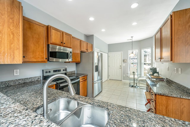 kitchen featuring a sink, recessed lighting, stainless steel appliances, brown cabinetry, and light tile patterned floors