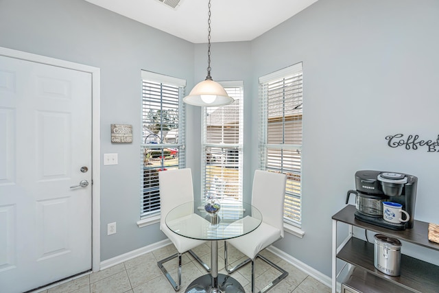 dining space featuring light tile patterned floors, baseboards, and plenty of natural light