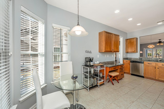 kitchen with visible vents, brown cabinets, stainless steel dishwasher, and hanging light fixtures