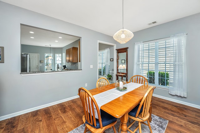 dining space featuring wood finished floors, baseboards, visible vents, and a wealth of natural light