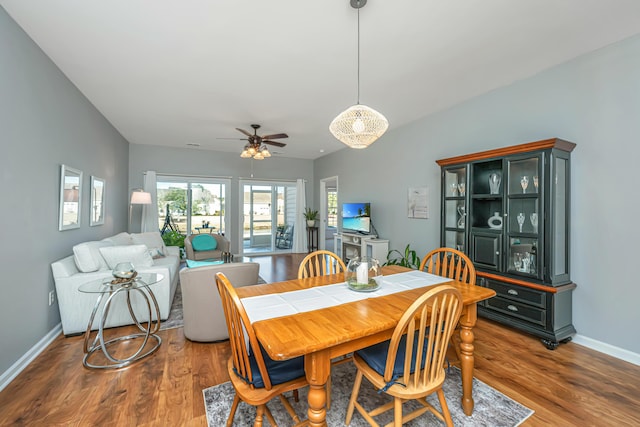 dining space featuring wood finished floors, baseboards, and ceiling fan