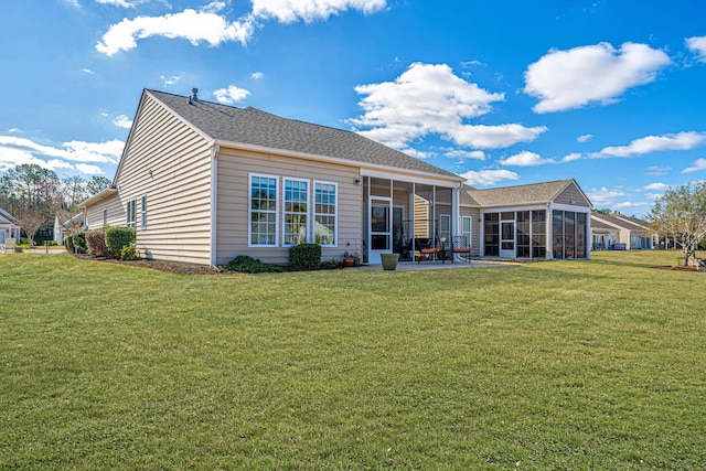 rear view of house featuring a lawn and a sunroom