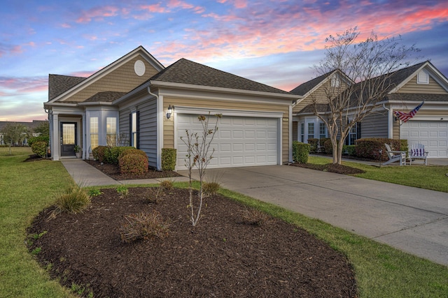 view of front of home featuring an attached garage, a shingled roof, driveway, and a front yard