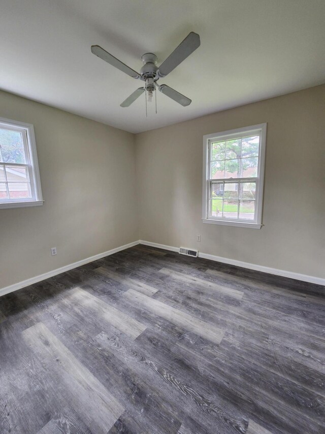 unfurnished room featuring dark wood-type flooring and ceiling fan