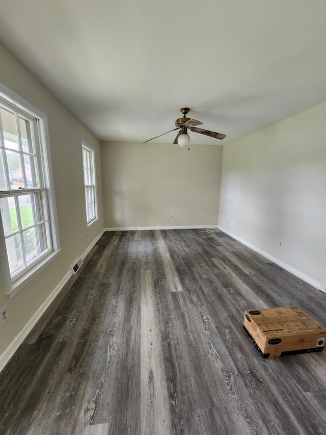 spare room with dark hardwood / wood-style flooring and ceiling fan