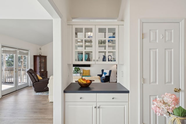 bar featuring white cabinetry, light hardwood / wood-style flooring, french doors, and vaulted ceiling