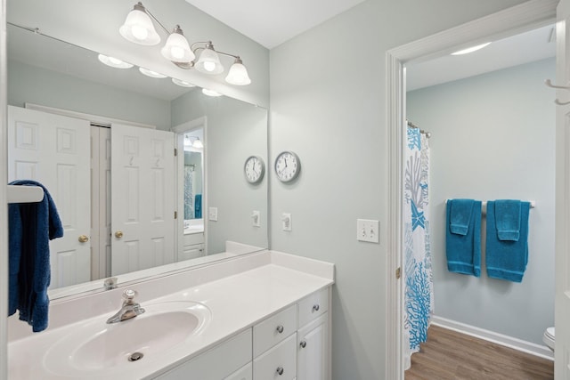 bathroom with hardwood / wood-style flooring, vanity, and toilet