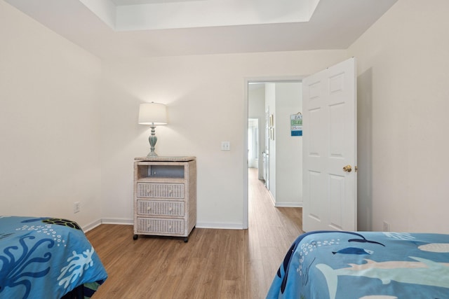 bedroom featuring hardwood / wood-style flooring and a raised ceiling