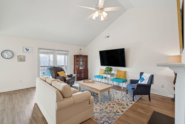 living room with hardwood / wood-style flooring, ceiling fan, and high vaulted ceiling