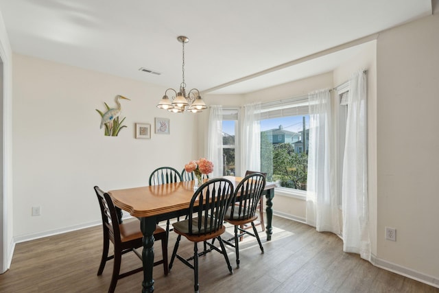 dining space with an inviting chandelier and hardwood / wood-style flooring