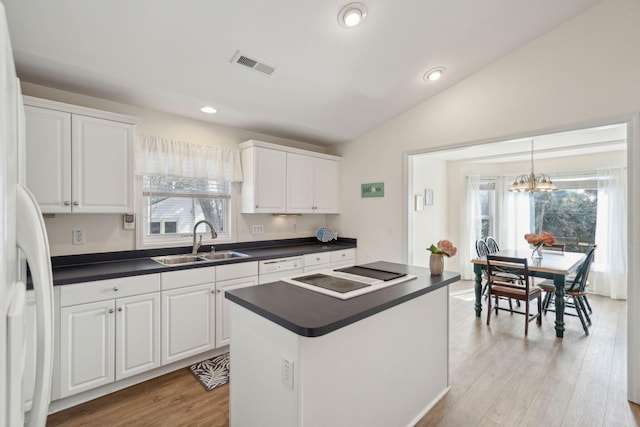 kitchen featuring a kitchen island, sink, white cabinets, and black electric cooktop