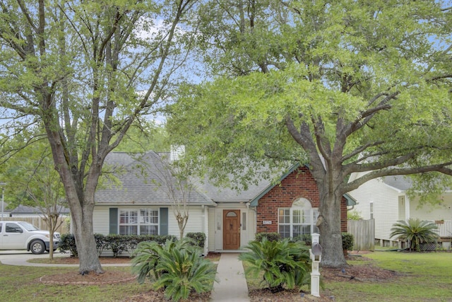 view of front of house featuring a shingled roof and fence
