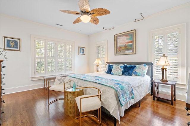 bedroom featuring multiple windows, wood finished floors, visible vents, and crown molding