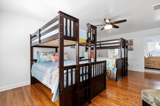 bedroom with wood finished floors, visible vents, and baseboards