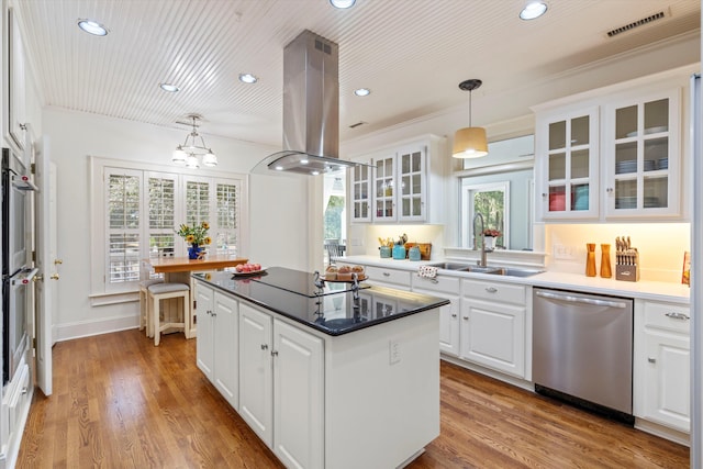 kitchen with white cabinets, island range hood, stainless steel appliances, and wood finished floors